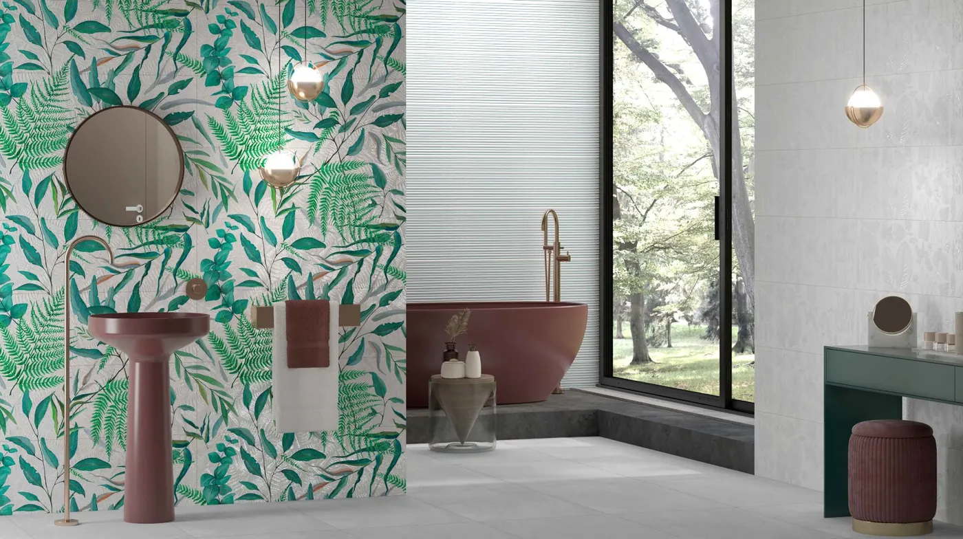 Colourful leaf-print wall tiles behind a red bathtub
